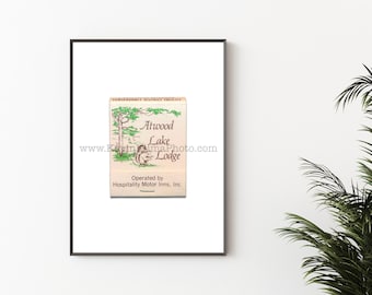 May include: A framed print featuring a vintage matchbook design for Atwood Lake Lodge. The matchbook has a cream-colored background with green and brown illustrations of a tree and a squirrel. The text includes "Conservancy District Facility" and "Operated by Hospitality Motor Inns, Inc."