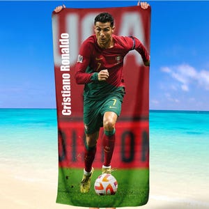 Könnte beinhalten: Ein rot-grünes Strandtuch mit einem Foto von Cristiano Ronaldo beim Fußballspielen. Das Handtuch trägt den Text "Cristiano Ronaldo".