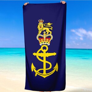 May include: A navy blue beach towel with a gold anchor and a crown with a lion. The crown is red, white, and gold. The lion is gold.