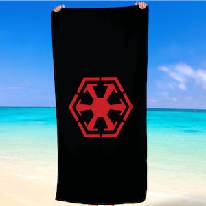 Könnte beinhalten: Schwarzes Strandtuch mit einem roten imperialen Symbol aus Star Wars.