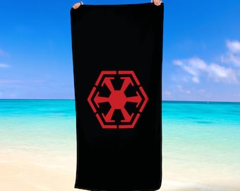 Könnte beinhalten: Schwarzes Strandtuch mit einem roten imperialen Symbol aus Star Wars.