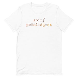 Op de afbeelding: Wit T-shirt met de tekst "spit/pa&infin;al3dist" gedrukt in een verloop van bruin, oranje en geel.