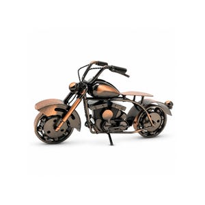 May include: A miniature motorcycle sculpture crafted from dark metal with a polished copper-toned finish on the fuel tank, fenders, and front forks. The model features detailed handlebars, a central engine block, and two wheels.