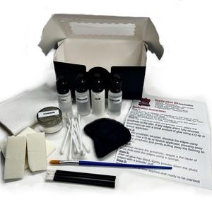 May include: A makeup application kit with various components, including bottles of liquids labeled PPS, Remover, Glue, and Acetone, a jar of powder, applicators, and a black sponge. The kit also includes a brush, cotton swabs, and a printed instruction sheet.