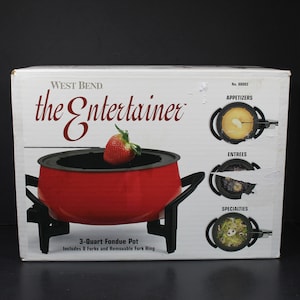 May include: A red 3-quart fondue pot with a black stand and a removable fork ring. The box features the text "WEST BEND the Entertainer" and shows different uses for the fondue pot, including appetizers, entrees, and specialties.