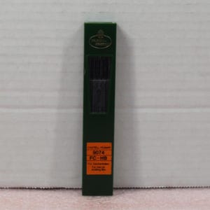 May include: A green plastic box of Castell 9074 FC-HB mechanical pencil leads. The box has a label with the product information.