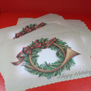 May include: A stack of holiday cards with a festive design. Each card features a gold-colored French horn surrounded by a green wreath and a red and green ribbon. The words "Happy Holiday" are printed on the bottom.