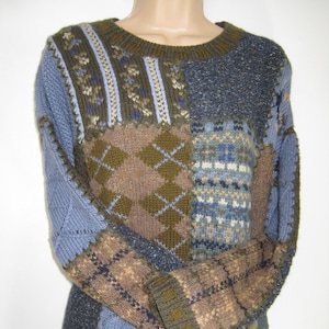 Puede incluir: Un suéter de punto de color azul, marrón y verde con un cuello redondo.