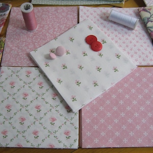 Pode incluir: Variedade de quadrados de tecido com padr&otilde;es florais e geom&eacute;tricos, em tons de rosa, branco e bege. Inclui carret&eacute;is de linha e bot&otilde;es, sugerindo um projeto de costura ou patchwork. Os tecidos est&atilde;o dispostos sobre uma superf&iacute;cie de madeira.
