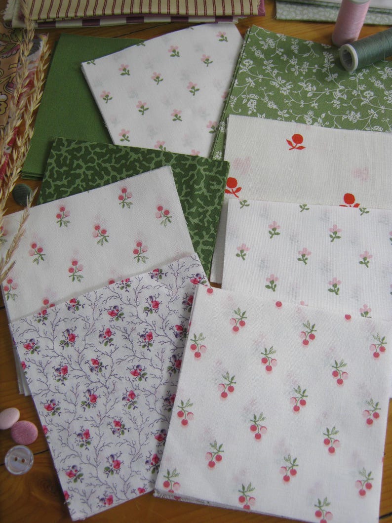 May include: Assortment of fabric squares in various floral patterns. White fabric with pink flowers, green fabric with white flowers, and green fabric with a speckled design. Also, fabric with red berries and purple floral branches.