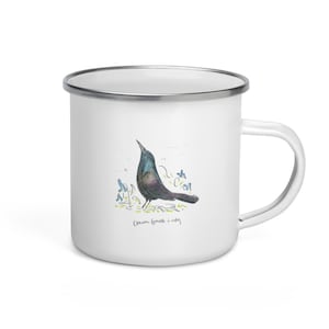 Può includere: Tazza in smalto bianco con un'illustrazione di un uccello nero e blu e il testo "Common Grackle in spring".