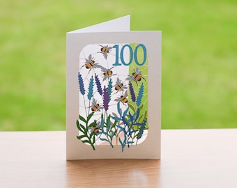 Puede incluir: Una tarjeta blanca con un diseño recortado de flores de lavanda y abejas. El número "100" está en el centro de la tarjeta en azul.