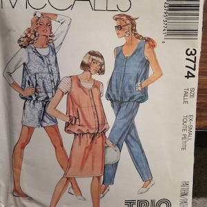 May include: A sewing pattern for a trio of outfits, featuring a blue and white patterned jumpsuit, a pink and white patterned jumpsuit, and a blue denim jumpsuit. The pattern is for sizes extra small to petite. The pattern is by McCall's and is called "Trio...and baby makes three".