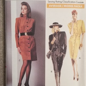 May include: Vogue Patterns sewing pattern number 7304 for sizes 12-14-16. The pattern includes three different dress styles: a brown dress with a button-up front, a black dress with a belt and a yellow dress with a belt. The pattern is labeled "Average/Moins Facile" for sewing difficulty.