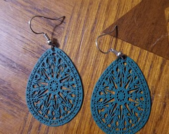 Pode incluir: Brincos em forma de lágrima azul turquesa com um design delicado e intrincado cortado a laser. Os brincos têm um gancho prateado.