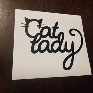 May include: Black and white vinyl decal with a cat silhouette and the text "Cat Lady" in a cursive font.