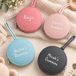 May include: Four round silicone dummy cases with zip closures and wrist straps. Each case features a chevron pattern and white text: Raya, Violet's Dummies, Archie's Dummies, and Micah's Dummies. The cases are coloured pink, light pink, blue, and dark grey.