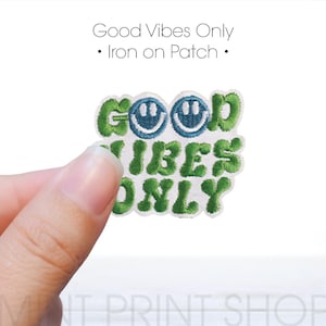 Puede incluir: Parche de planchado bordado en verde y azul con el texto "Good Vibes Only" y dos caras sonrientes.