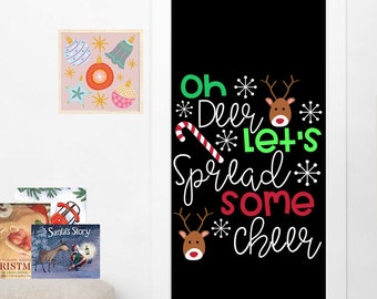 May include: Black doormat with white text that reads "Oh Deer Let's Spread Some Cheer" with a red and white candy cane, snowflakes, and a red reindeer head with antlers.