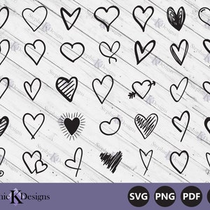 May include: A set of 28 hand-drawn heart designs in black on a white wood background. The hearts are in various styles and sizes, including simple outlines, filled-in hearts, and hearts with swirls and other details.