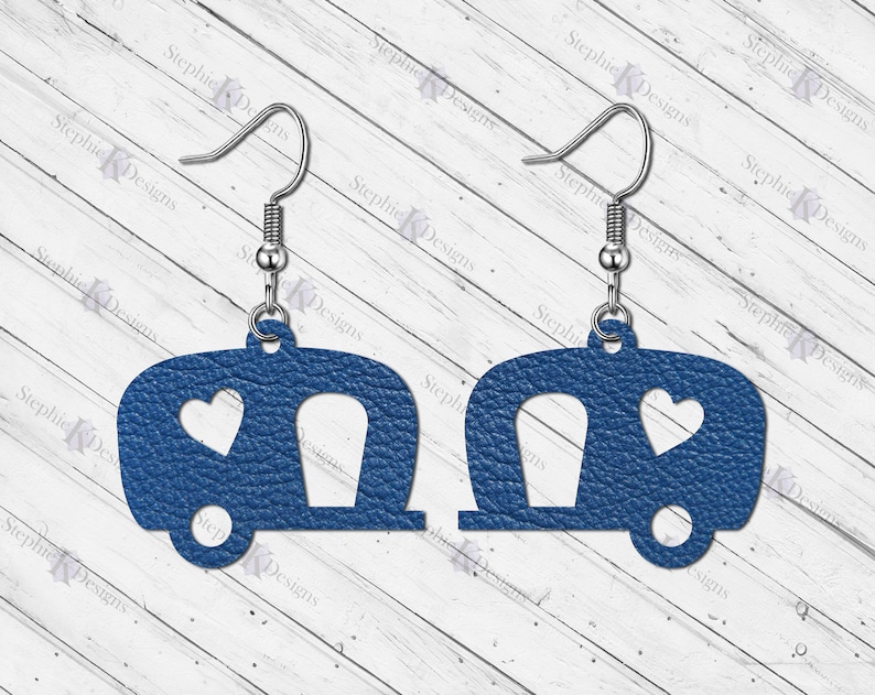 May include: A pair of blue camper earrings with a heart cutout. The earrings are made of leather and have silver hooks.