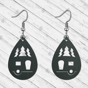 May include: A pair of dark green teardrop-shaped earrings with a camper and pine trees cut out. The earrings are made of leather and have silver hooks.