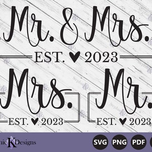 May include: Black and white graphic design with the text "Mr. & Mrs. EST. 2023" and "Mrs. Mr. EST. 2023" in a cursive font. The text is framed with a simple black border.
