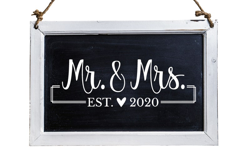 May include: A white framed chalkboard sign with the text "Mr. & Mrs. EST. &hearts; 2020" written in white chalk.