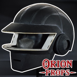 May include: A black helmet featuring a wide visor opening with white interior trim, a prominent brim, and circular side ear pieces. The helmet has a smooth, matte finish and a structured design. The text ORION PROPS is displayed in red and white.