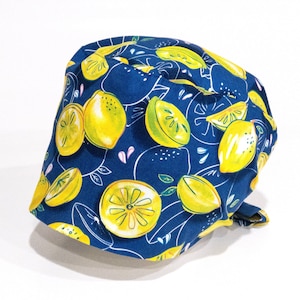 Peut inclure: Un bonnet de scrub en tissu bleu avec un imprimé citron. Le bonnet a un motif de citron jaune sur un fond bleu foncé.