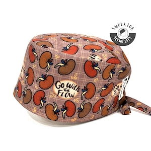 May include: A brown and tan patterned scrub cap with the text "Go With The Flow" in yellow and blue. The cap has a tie at the back and a small logo that says "Superior Scrub Caps".