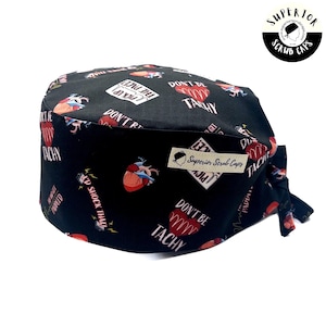 May include: Black scrub cap with a repeating pattern of anatomical hearts, text, and lightning bolts. The text includes phrases like "Don't be Tachy" and "Pick up the pace". A small tag reads "Superior Scrub Caps".