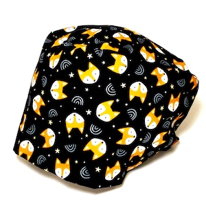 May include: Black fabric with a repeating pattern of orange fox faces and white stars on a black background.