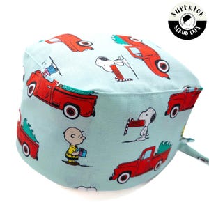 May include: A blue and white scrub cap with a red truck and Peanuts characters print. The text "Superior Scrub Caps" is printed on the cap.