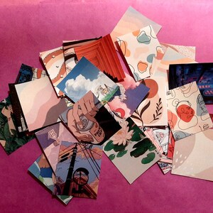 Może przedstawiać: Zbi&oacute;r kolorowych kwadrat&oacute;w z papieru z r&oacute;żnymi wzorami, w tym abstrakcyjnymi wzorami, ilustracjami kwiat&oacute;w i panoramą miasta. Kwadraty są ułożone w stos na r&oacute;żowym tle.