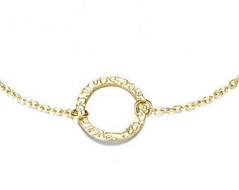 Peut inclure: Un bracelet en chaîne dorée avec un pendentif rond texturé.