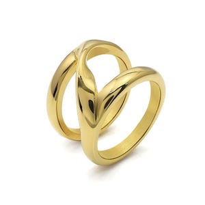 May include: A gold ring with an unusual, interwoven design. The ring has two bands that curve and overlap, creating a stylish and modern appearance. The polished surface reflects light, highlighting the ring's smooth texture and elegant form.