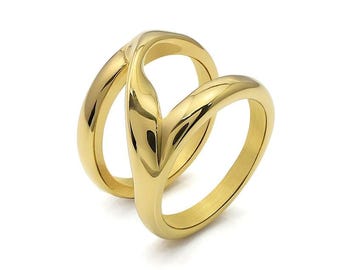May include: A gold-colored ring with a unique, intertwined design. The ring features two bands that curve and overlap, creating a stylish and modern look. The polished surface reflects light, highlighting the ring's smooth texture and elegant form.