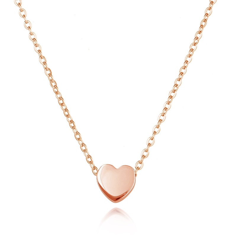 May include: A delicate rose gold necklace with a small heart pendant.