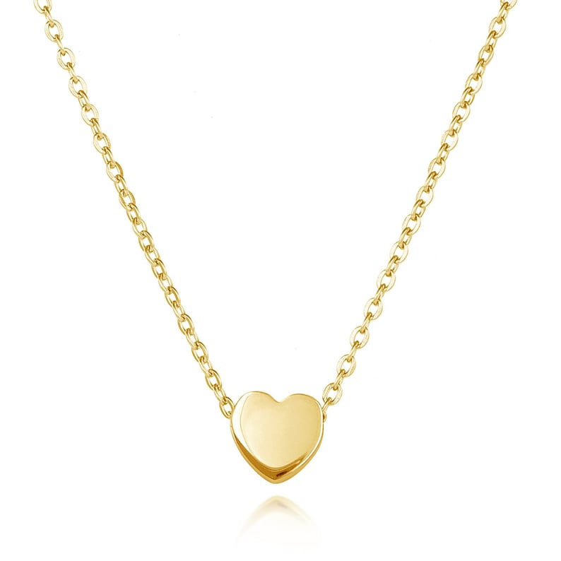 May include: A delicate gold chain necklace with a small, smooth heart pendant.