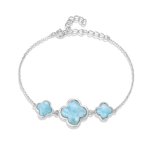 Könnte beinhalten: Ein silbernes Armband mit drei blauen Kleeblatt-Anhängern. Die Anhänger sind aus Aquamarin und in Silber gefasst.