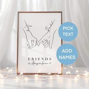 May include: A framed print featuring a minimalist line drawing of two hands holding pinky fingers. The names "Amy" and "Rachel" are written above the hands. The words "FRIENDS Always & Forever" are below the hands. Two blue circles with text are on the right.