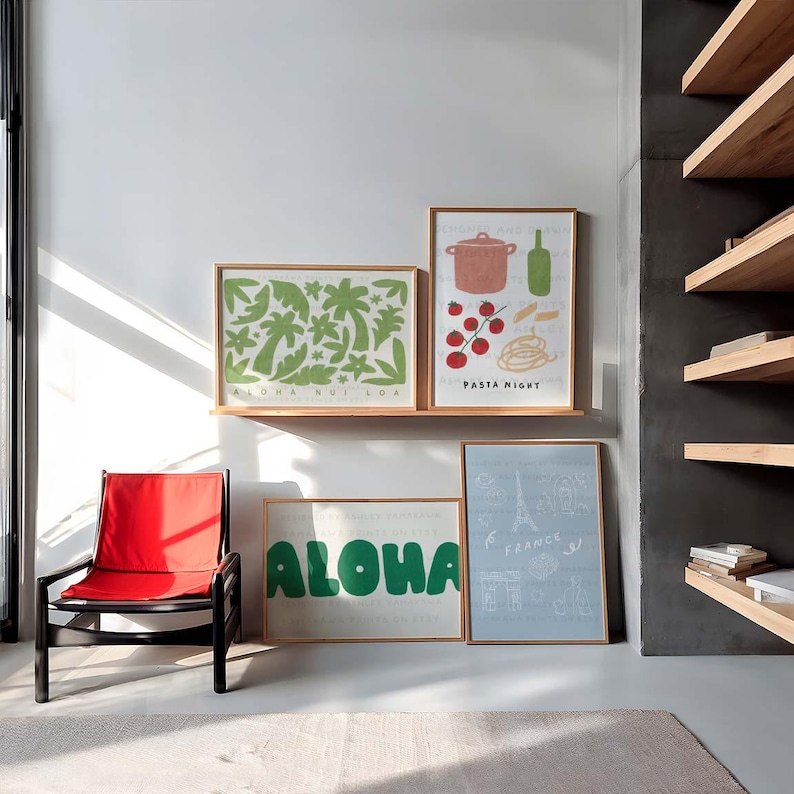May include: Four framed prints on a white wall with a red chair in the foreground. The prints feature illustrations of palm trees, pasta, a pot, tomatoes, and the word "Aloha". The fourth print features a drawing of the Eiffel Tower and the words "Paris, France".