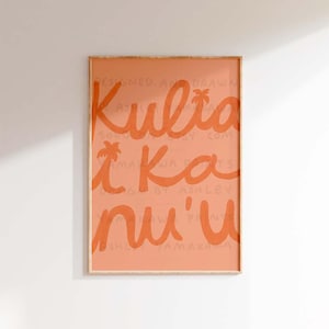 May include: A peach-colored framed print with the text "Kuliakau'i" in orange. The text is in a handwritten style with palm trees incorporated into the letters.