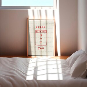 Peut inclure: Une impression encadr&eacute;e avec un fond blanc et du texte rouge. Le texte dit "DESIGNED AND DRAWN BY ASHLEY YAMAKAWA SOLO 7 PRINTS.COM YAMAKAWA PRINTS DESIGN 7 ASHLEY YAMAKAWA PRINTS ASHLEY YAMAKAWA YOU". L'impression pr&eacute;sente une illustration rouge d'une bo&icirc;te d'allumettes avec le chiffre "7" &eacute;crit quatre fois &agrave; l'int&eacute;rieur.