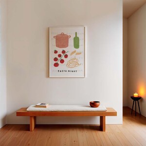 May include: A white framed print with a hand-drawn illustration of a pot, tomatoes, pasta, and a bottle of wine. The text "PASTA NIGHT" is written below the illustration.