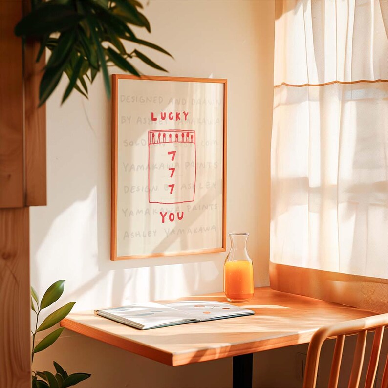 Peut inclure: Une impression encadr&eacute;e avec un fond blanc et du texte rouge qui dit "Lucky You" avec un dessin d'un bocal avec le chiffre 7 &eacute;crit &agrave; l'int&eacute;rieur quatre fois. L'impression est accroch&eacute;e &agrave; un mur blanc.