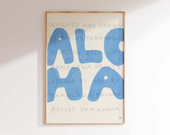 May include: A blue and white print with the word "ALOHA" in large, stylized letters. The print is framed and has the text "DESIGNED AND DRAWN BY ASHLEY YAMAKAWA" at the top and "ASHLEY YAMAKAWA" at the bottom.