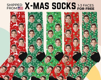 May include: Five pairs of crew socks featuring a repeating pattern of a person's face interspersed with holiday motifs including snowflakes, holly, gingerbread men, and candy canes. The text reads X-MAS SOCKS 1-3 FACES FOR FREE.