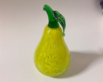 May include: A yellow glass pear with white speckles and a green glass stem and leaf.